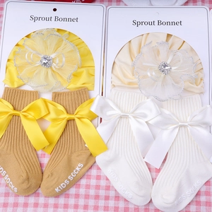 Detail of newborn lace floral bonnet and ribbed socks with large bows and anti-slip soles