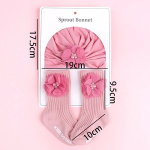 Vue détaillée de l'ensemble bonnet à fleurs rose et chaussettes pour nouveau-nés