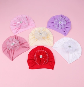 Détail de turbans pour bébé avec grandes fleurs en maille et cristaux scintillants