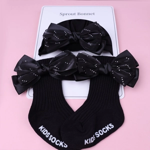 Détail d'un ensemble bonnet et chaussettes en coton pour bébé avec nœuds et strass