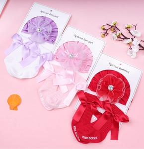 Detailed set of lace flower newborn hats and ribbon socks in pink, purple, and red tones