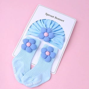 Detail of ribbed knit baby headband and socks set with 3D floral accents in light blue