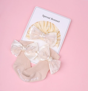 Détail d'un bonnet turban et chaussettes bébé avec grands nœuds en organza à paillettes