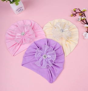 Détail de turbans pour bébé avec fleurs en tulle multicouches et cristaux centraux