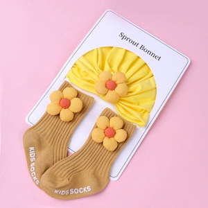 Detail of yellow knit bonnet and brown socks set with 3D flower accents for infants