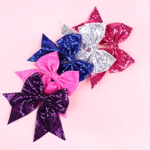 Detailed view of colorful sequined bow hair clips in purple, pink, blue and silver