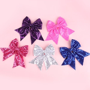 Detailed view of five colorful sequined bow hair clips for girls' performances