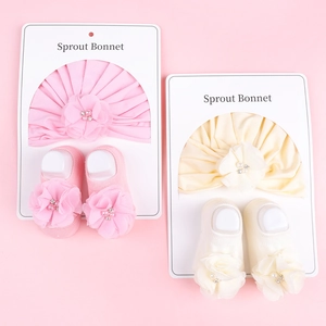 Détails d'un ensemble de turban et chaussettes pour bébé rose et beige avec fleurs