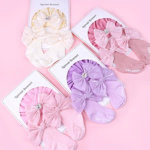 Détail de l'ensemble bonnet et chaussettes pour bébé avec grands nœuds en strass en quatre couleurs
