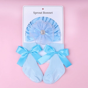 Detail of baby lace flower headband and bow socks set on white packaging card