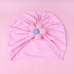 Detail view of pink baby knit turban hat featuring a 3D floral decoration