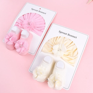 Détail d'un ensemble bandeau turban et chaussettes bébé avec fleurs 3D et perles