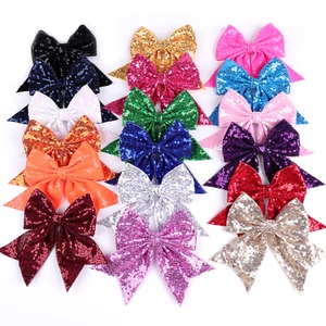 Flat lay of 15 colorful sequin bow hair clips for girls in a vibrant variety of shades