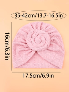 Pink infant turban hat with large rose knot and detailed size measurements shown