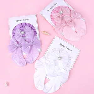 Détail du coffret bandeau et chaussettes bébé avec nœuds satinés et strass