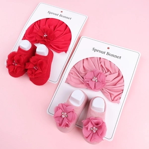 Vue à plat de bandeaux à fleurs et chaussettes assorties pour bébés en rose et rouge