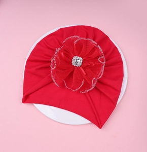 Détail du bonnet turban rouge pour bébé avec grande fleur en dentelle et strass carré