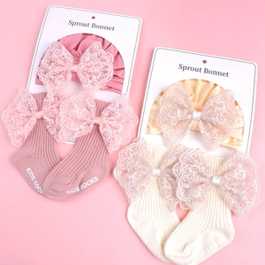 Knitted baby bonnet and socks set with lace bows in pink and cream white colors
