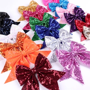 Various colorful sequined bow hair clips with long tails displayed on a white background