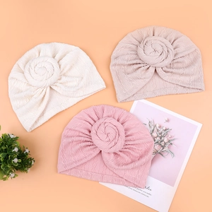 Three-piece baby ribbed knit hats with donut knot detail in white, pink and mauve colors