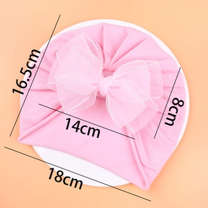 Pink infant turban hat with double lace bow detailing and specific size measurements