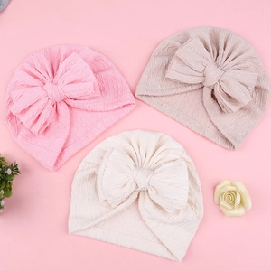 Bonnets bébé fille avec nœud jacquard en rose, beige et crème avec texture tricotée