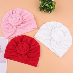 Detailed cable knit texture and donut knot design on baby turbans in three soft colors