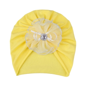 Détail du turban jaune pour bébé avec fleur en tulle et centre orné d'un strass brillant