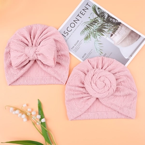 Detailed knit texture of pink baby turban hats with bow and twist knot styles