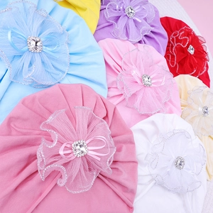 Close-up of baby turbans with lace flowers and diamond ribbons in various candy colors