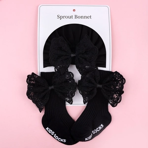 Detail of baby headband with lace bow and ribbed socks set on a display card