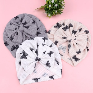 Close-up of waffle texture baby turbans with black butterfly print and large bow detail