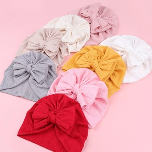Texture tricotée détaillée et grands nœuds sur des bonnets jacquard doux pour bébé