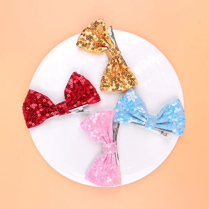 Detailed view of four colorful sequin bow hair clips in gold, red, pink, and light blue