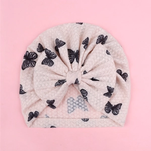Detail of pink waffle knit baby turban with oversized bow and black butterfly prints