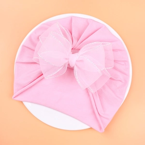 Close-up of pink baby turban hat featuring a large layered mesh bow with silver trim