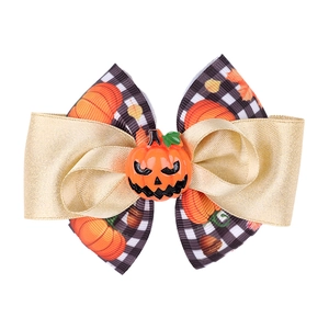 Détail de la pince à cheveux nœud Halloween avec ruban doré, motif à carreaux et citrouille