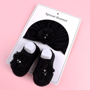 Détail d'un ensemble turban et chaussettes bébé avec fleurs en mousseline de soie