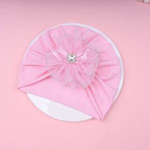 Detailed view of pink baby hat with large mesh lace flower and sparkling rhinestone