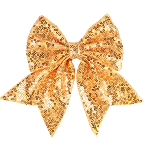 Close-up of golden sequin embroidery on large bow hair clip with flowing long tails