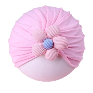 Pink knitted baby turban hat with a large floral decoration for infant girls