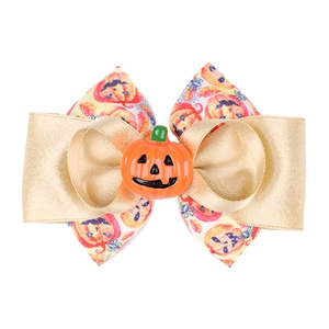 Détail de la pince à cheveux Halloween avec ruban à motif citrouille et nœud doré
