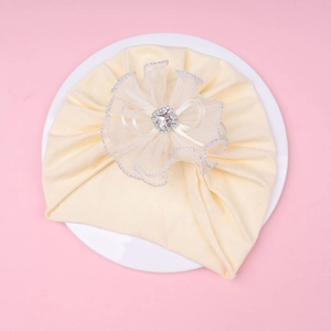 Detail of baby hat with lace flower, square rhinestone, and delicate ribbon bow