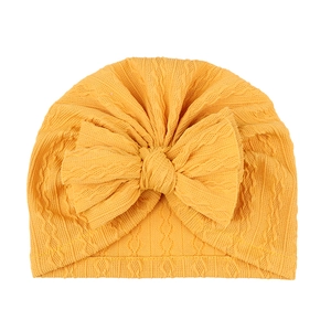 Texture de maille détaillée et grand nœud sur bonnet turban jaune pour bébé