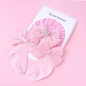 Ensemble bandeau et chaussettes rose pour bébé avec nœuds satinés et détail diamant