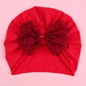 Detailed top view of red infant turban hat with a large double-layer lace bow decoration