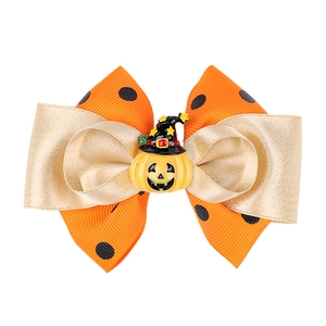 Détail d'une pince à cheveux Halloween avec ruban orange à pois et chapeau de sorcière