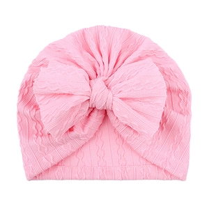 Détail du bonnet turban pour bébé avec texture torsadée et grand nœud rose pour fille