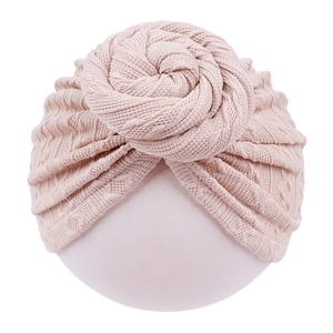 Macro shot of knitted infant turban with donut knot in soft apricot beige fabric