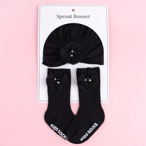 Détail de l'ensemble bonnet et chaussettes pour bébé avec fleurs en perles